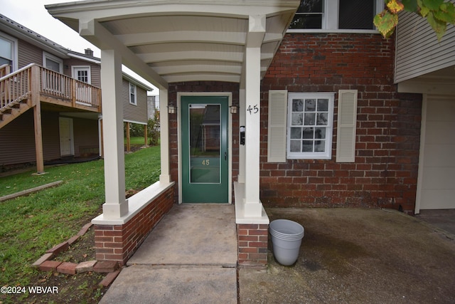 property entrance featuring a lawn