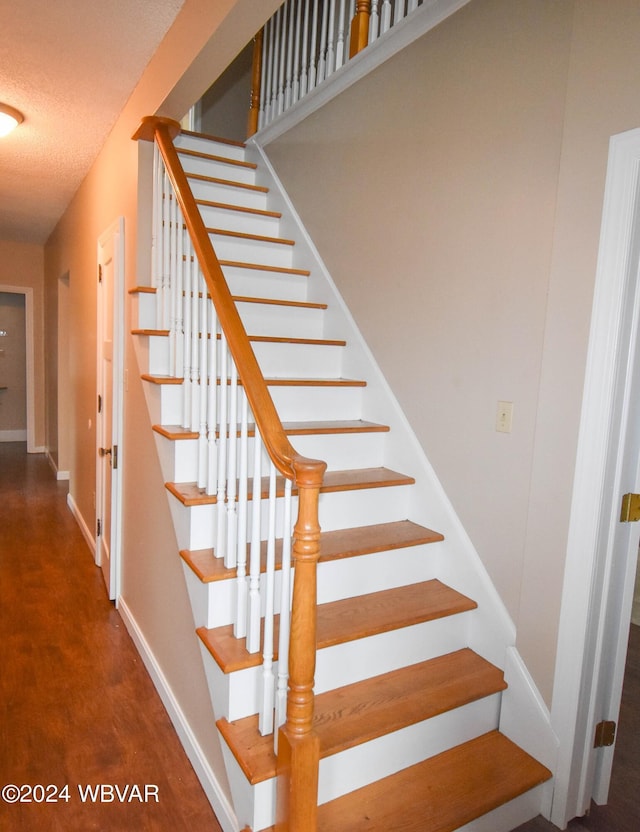 stairs with a textured ceiling