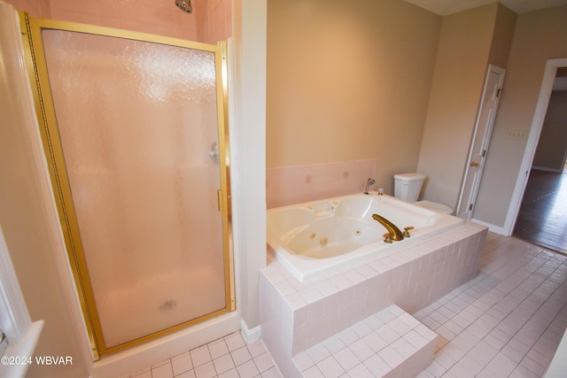 bathroom featuring tile patterned flooring, toilet, and shower with separate bathtub