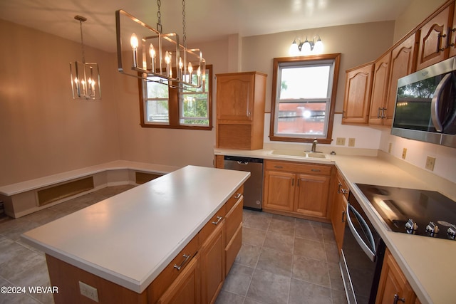 kitchen with stainless steel appliances, sink, tile patterned flooring, a kitchen island, and hanging light fixtures