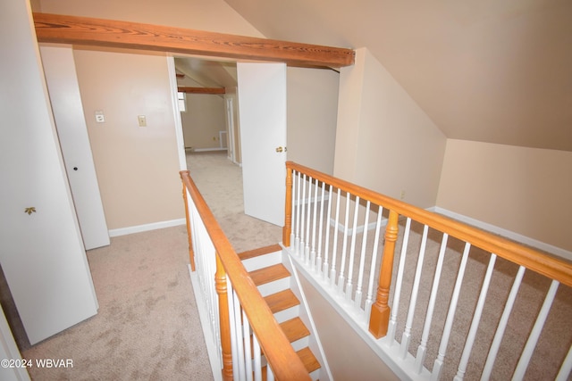 hallway with light colored carpet and lofted ceiling