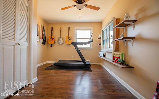 exercise area with dark wood-type flooring and ceiling fan