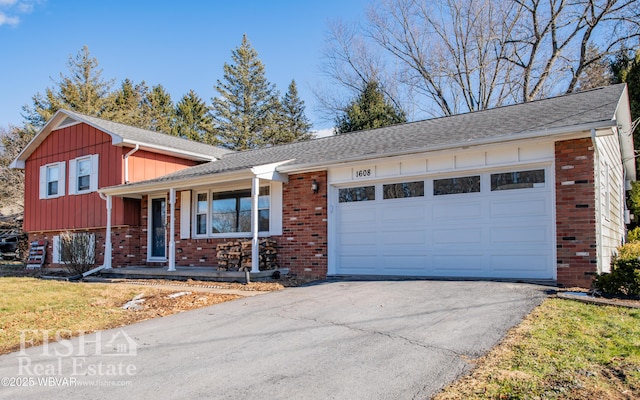 split level home featuring a garage, a front lawn, and covered porch