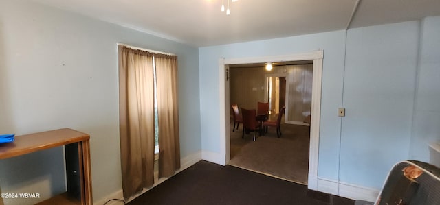 hall featuring dark colored carpet