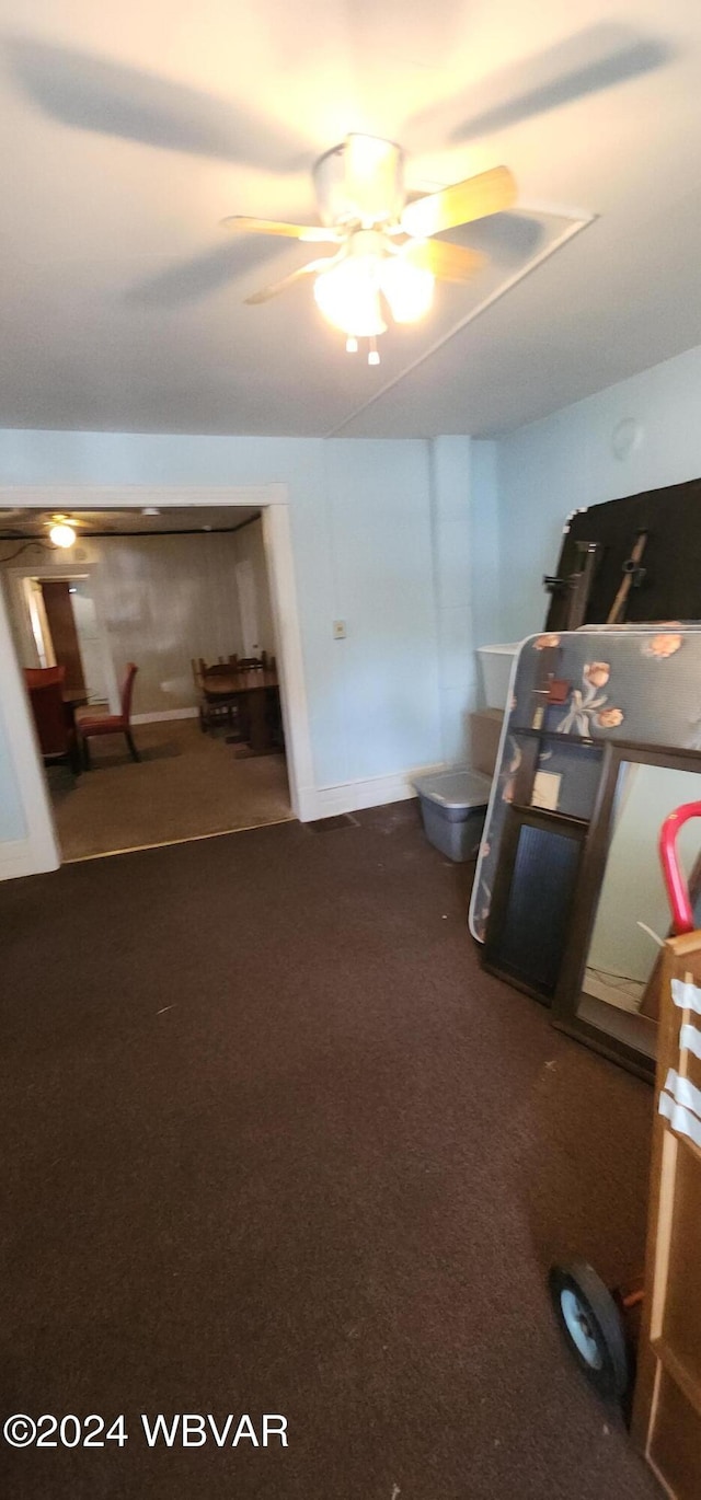 interior space featuring ceiling fan and carpet