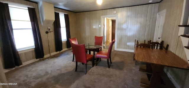 carpeted dining area with wooden walls