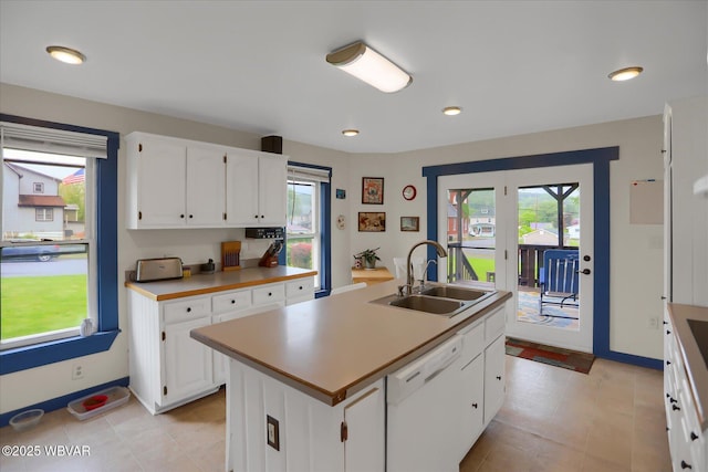 kitchen featuring a sink, white dishwasher, healthy amount of natural light, white cabinets, and recessed lighting