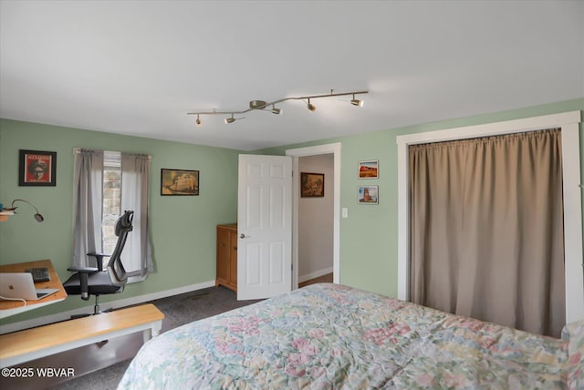 bedroom with track lighting and dark carpet