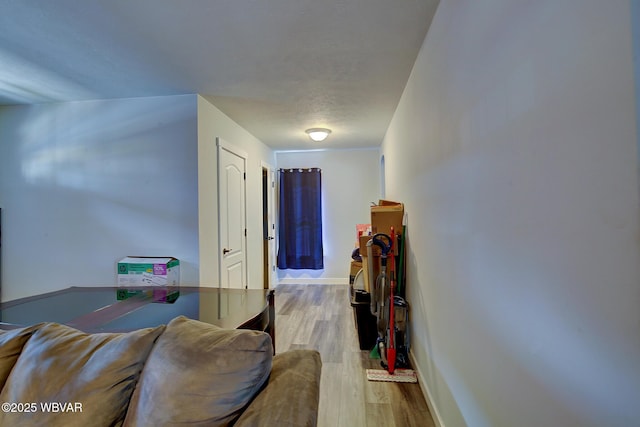 corridor with wood finished floors and baseboards