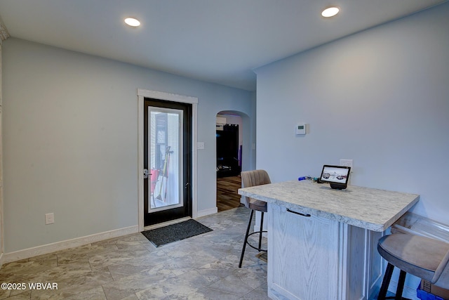 foyer featuring arched walkways, recessed lighting, and baseboards