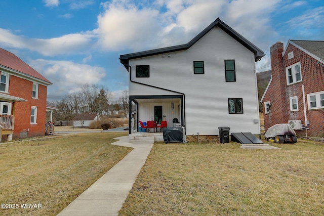 rear view of property with a yard and a patio