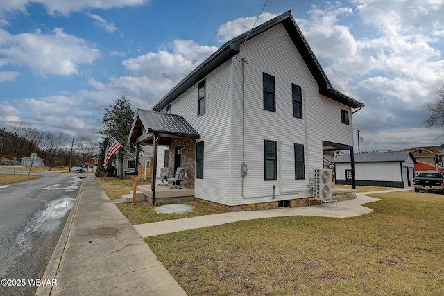 view of property exterior with metal roof, a lawn, and an outdoor structure