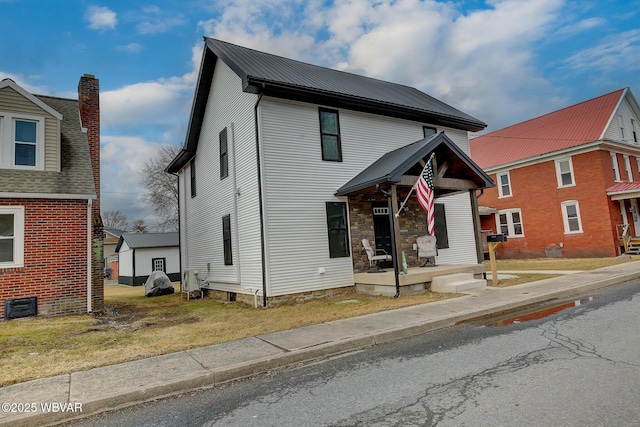 view of front of home with a porch, metal roof, and an outdoor structure