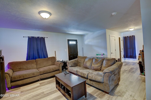 living area featuring light wood finished floors and a textured ceiling