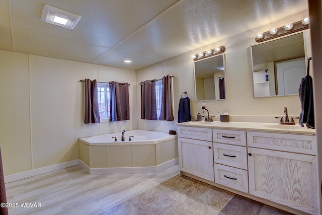 full bath featuring double vanity, a sink, and a bath