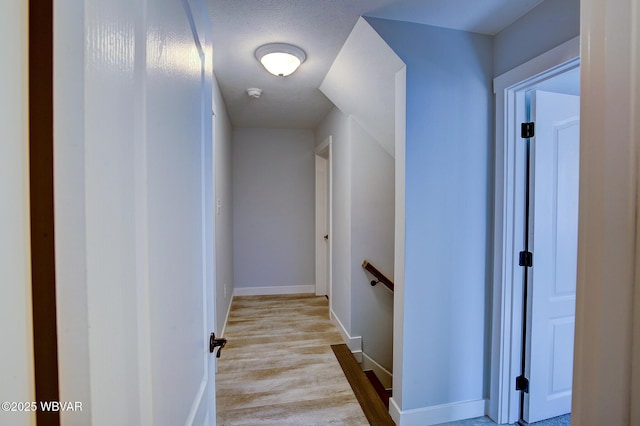 hallway with baseboards and wood finished floors