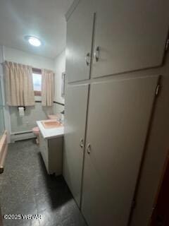 bathroom featuring a shower with door, a baseboard radiator, and vanity