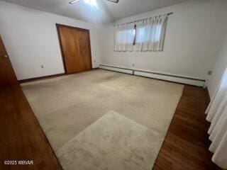 unfurnished bedroom with baseboard heating, ceiling fan, and a closet