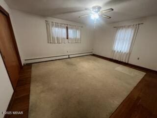 unfurnished room with a baseboard heating unit and ceiling fan