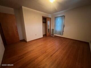 unfurnished bedroom with hardwood / wood-style flooring and a closet