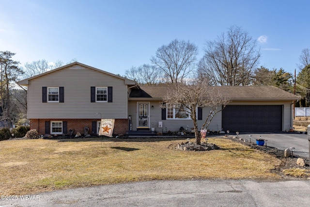 split level home with a front lawn, a garage, and aphalt driveway