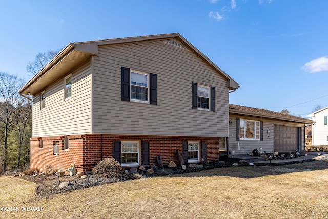 view of front of property with a front yard, an attached garage, and brick siding