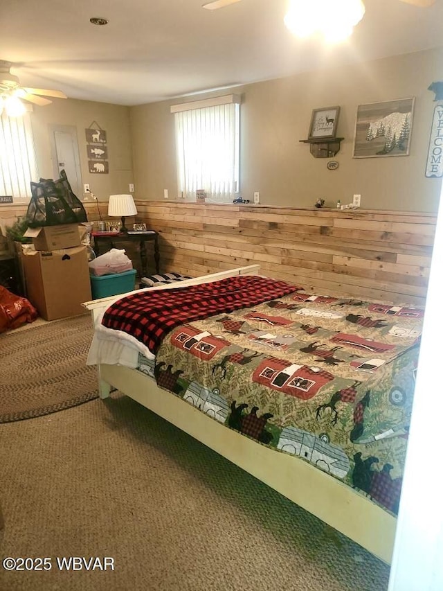 bedroom featuring wainscoting, carpet flooring, and wood walls