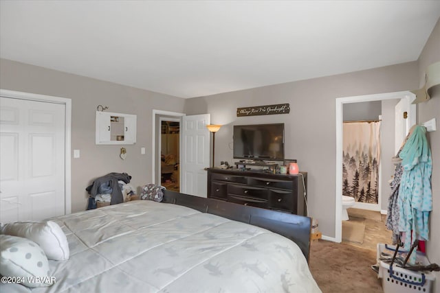 bedroom featuring carpet floors, ensuite bath, and baseboards