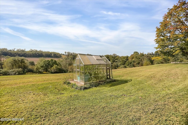 view of yard featuring an outdoor structure, an exterior structure, and a rural view