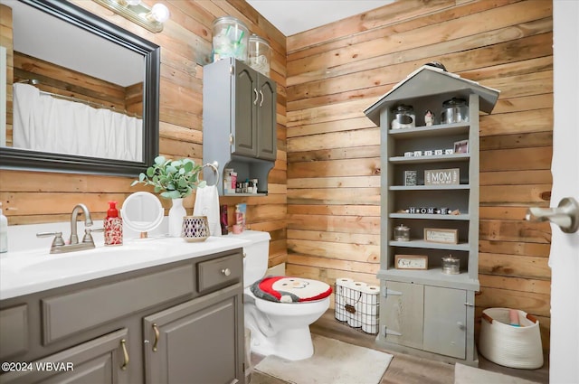 bathroom with toilet, vanity, and wooden walls