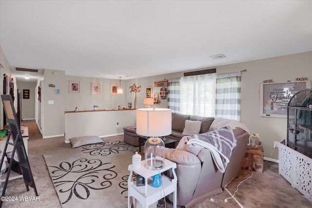 living room with light carpet, visible vents, and baseboards