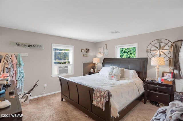 bedroom with light carpet, multiple windows, and cooling unit