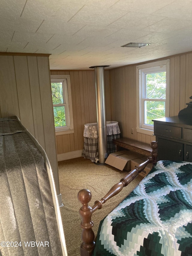 carpeted bedroom with wood walls