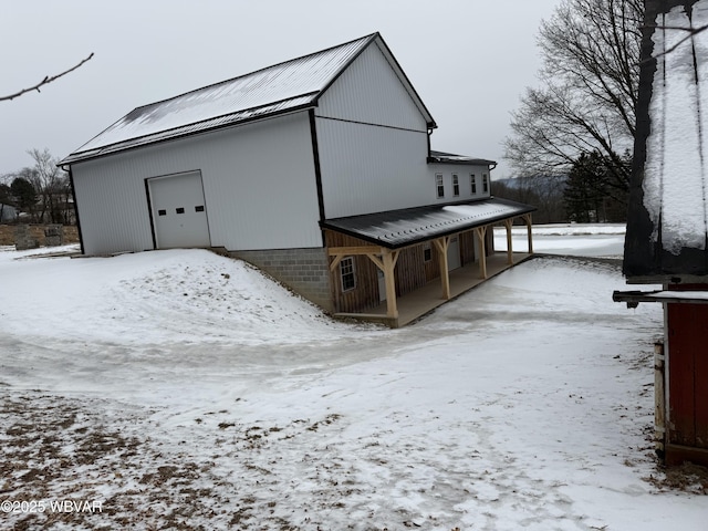 snow covered structure with a garage