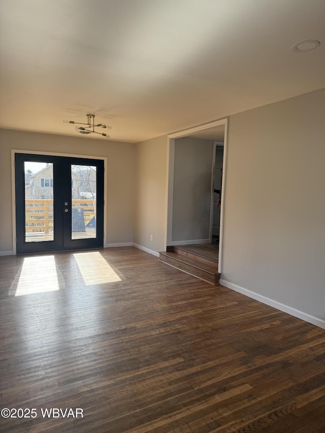 unfurnished room with dark wood-style floors, french doors, and baseboards