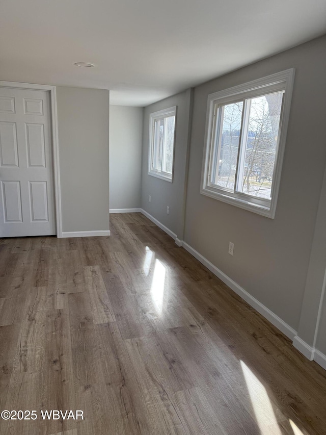 spare room featuring light wood-type flooring and baseboards