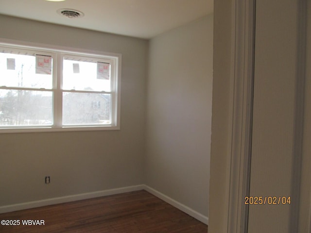 unfurnished room featuring dark wood-style floors, baseboards, and visible vents