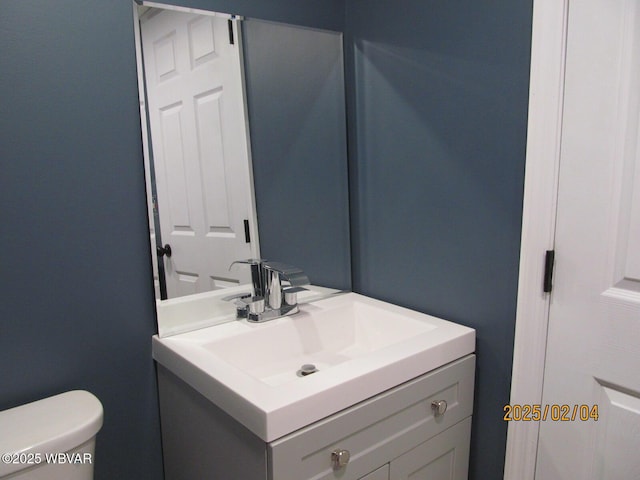 half bath featuring toilet and vanity