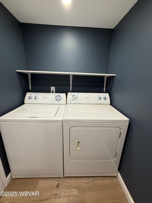 laundry room featuring washer and dryer and light hardwood / wood-style flooring