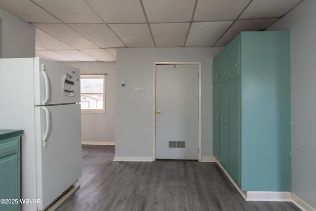 kitchen featuring white fridge, hardwood / wood-style floors, and a drop ceiling