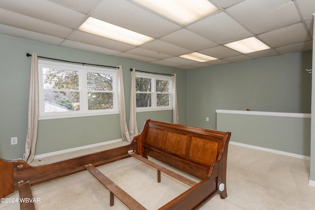 bedroom with light carpet and a drop ceiling