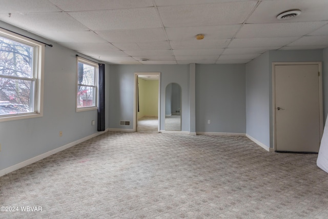 empty room with carpet flooring and a drop ceiling