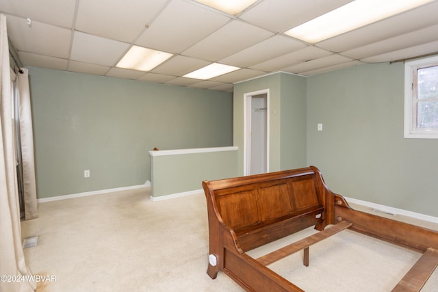 carpeted bedroom with a drop ceiling