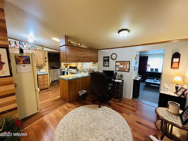 office space featuring sink, light hardwood / wood-style flooring, lofted ceiling, and washing machine and clothes dryer