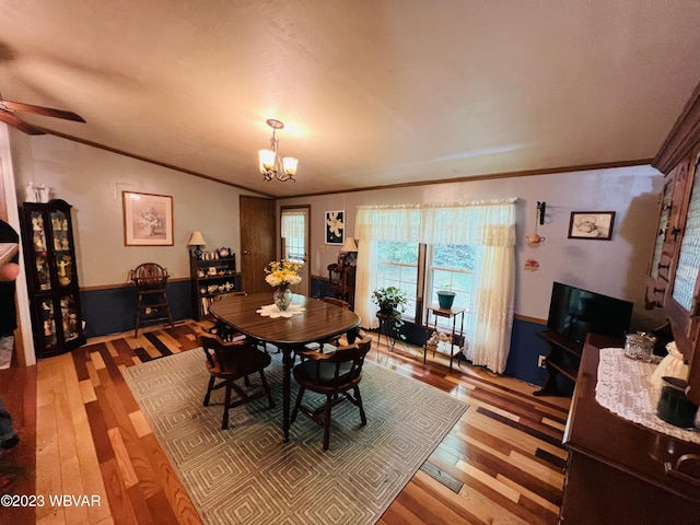 dining area with ornamental molding, ceiling fan with notable chandelier, and hardwood / wood-style flooring