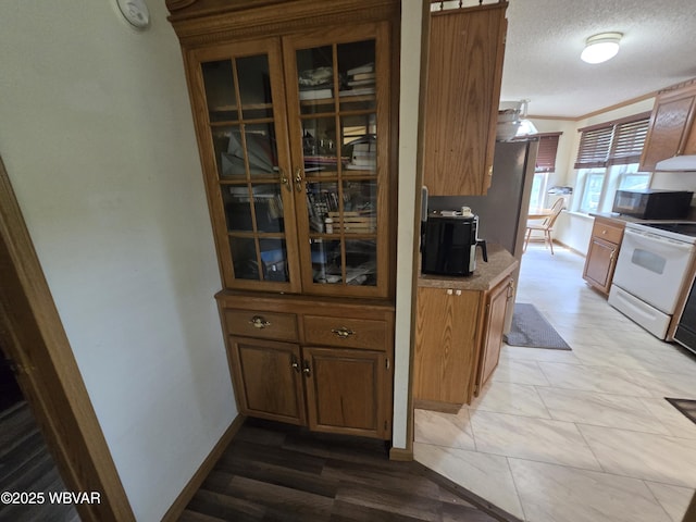4316 Pine Mountain Rd, Jersey Shore, PA 17740 - kitchen featuring electric stove, black microwave, brown cabinets, under cabinet range hood, and glass insert cabinets