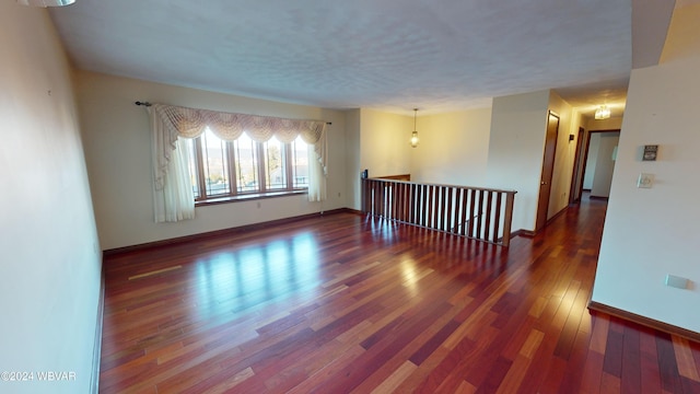 unfurnished room featuring dark hardwood / wood-style flooring and a chandelier