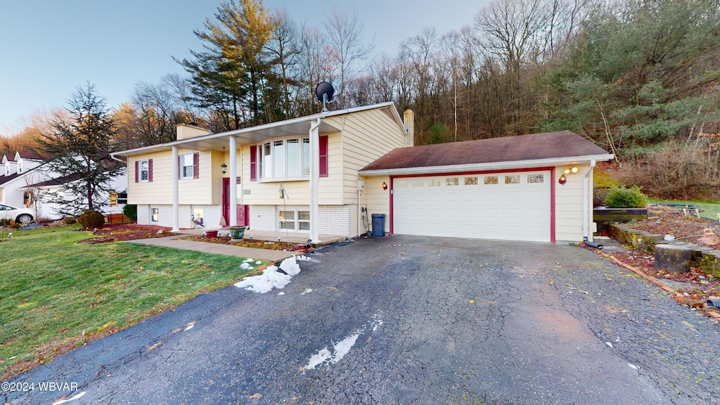 bi-level home featuring a front lawn and a garage