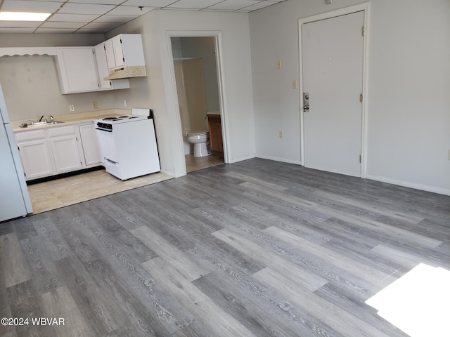 kitchen with light hardwood / wood-style flooring, white cabinets, a drop ceiling, and white appliances