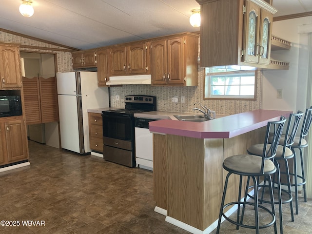 400 Livermore Rd, Williamsport, PA 17701 - kitchen featuring a peninsula, white appliances, a kitchen bar, under cabinet range hood, and a sink